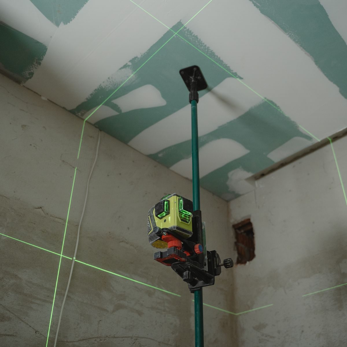 Nivel láser sobre cielorraso de durlock verde en instalación